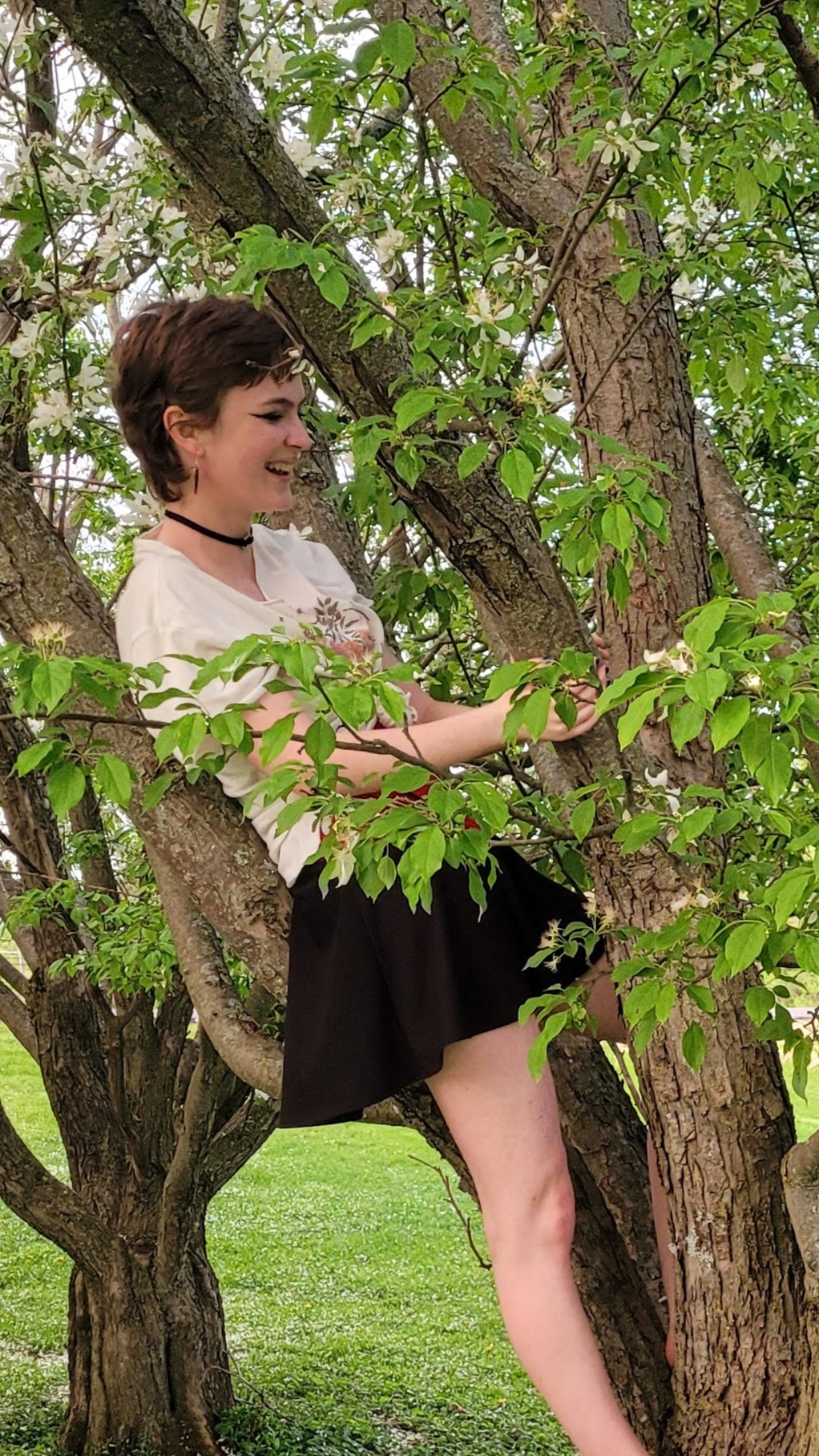 Lily laughing in a blossoming tree.